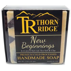 Packaging of Thorn Ridge soap labeled "New Beginnings" described as activated charcoal, sea salt, clay, premium cold processed, handmade, 5 oz. Made in USA.