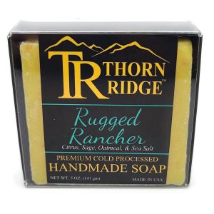 Packaging of Thorn Ridge soap labeled "Rugged Rancher," described as citrus, sage, oatmeal, sea salt, premium cold processed, handmade, 5 oz. Made in USA.